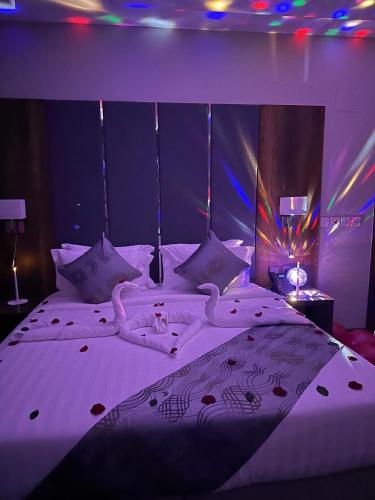 a bedroom with a bed with two swans on it at Golden Season Hotel - Al-Rass - فندق جولدن سيزون - الرس in Al Rass