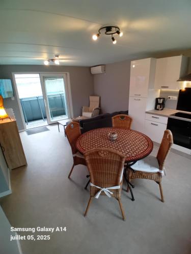 a living room with a table and chairs and a kitchen at Gîtes L'Evasion Thudinienne in Thuin