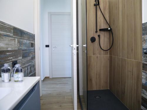 a bathroom with a shower with a wooden door at Affittacamere Brezza Di Sirolo in Sirolo