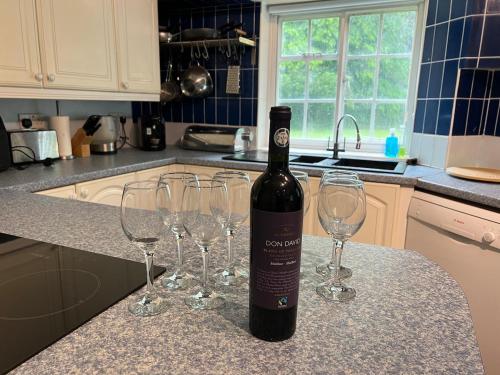 a bottle of wine sitting on a counter with wine glasses at Heron House in Warwick