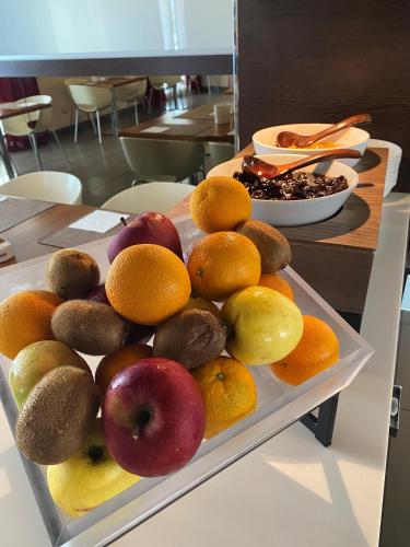 a tray of apples oranges and other fruits on a table at CAVALLO Hotel Noventa di Piave in Noventa di Piave