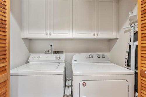 a kitchen with white cabinets and white appliances at White Dolphin Left in Corolla