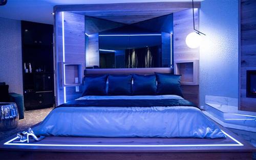 a large blue bedroom with a large bed in it at Le Fabreville Motel & Suites in Laval