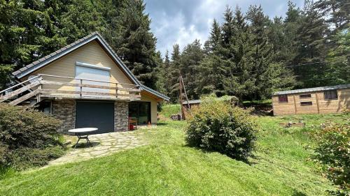 ein Haus mit einem Tisch vor einem Hof in der Unterkunft L'écrin ardéchois - Calme, forêt, lac privé in Saint-Agrève