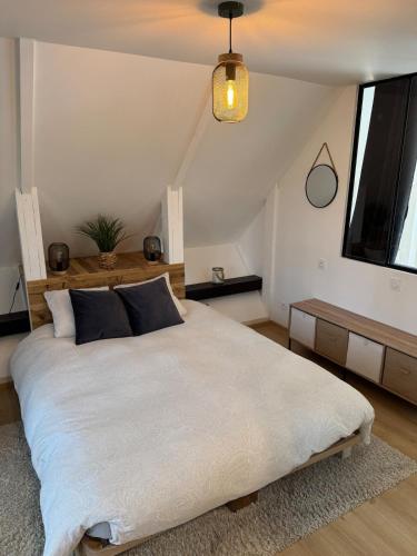 ein Schlafzimmer mit einem großen weißen Bett und einem Fenster in der Unterkunft L'écrin ardéchois - Calme, forêt, lac privé in Saint-Agrève