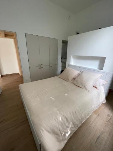 a bedroom with a large white bed with white cabinets at La Métairie in Vernou-sur-Brenne