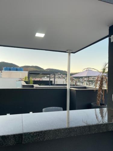 a patio with a table and chairs and an umbrella at Absolut Residense in João Monlevade