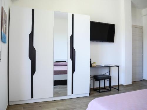 a bedroom with a sliding glass door with a tv at Affittacamere Brezza Di Sirolo in Sirolo