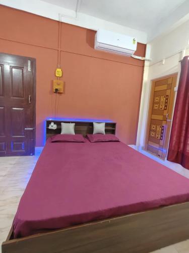 - une grande chambre avec un grand lit et des draps violets dans l'établissement Nest retreat home stay, à Jorhat