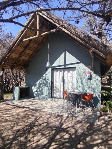 a house with a table and chairs in front of it at Aloe Bush Game Lodge in Marble Hall