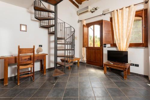 a living room with a spiral staircase and a desk at Agriturismo Terrenia in Taormina