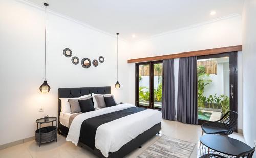 a bedroom with a large bed and a balcony at Villa Mimoza Umalas Bali in Kerobokan