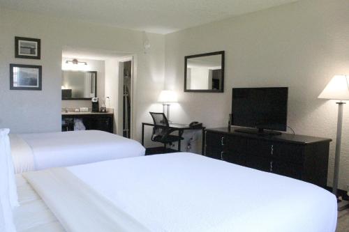 a hotel room with two beds and a flat screen tv at La Quinta Inn by Wyndham Cocoa Beach-Port Canaveral in Cocoa Beach