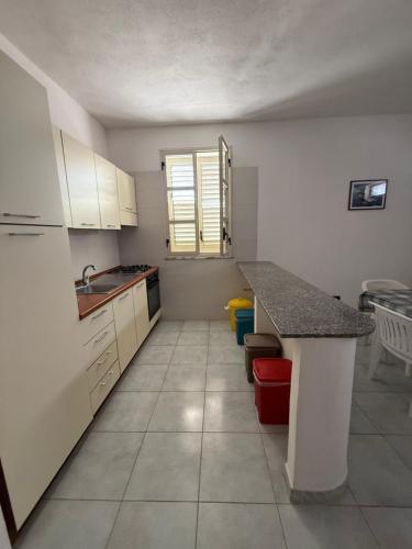 a kitchen with white cabinets and a counter top at Lopadusa trilo 2 in Lampedusa