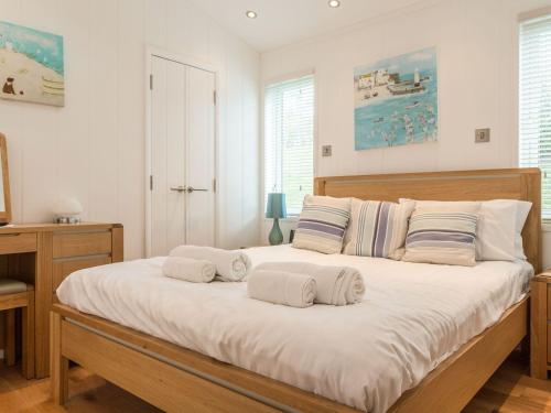 a bedroom with a large bed with towels on it at 2 Tree Tops in Looe