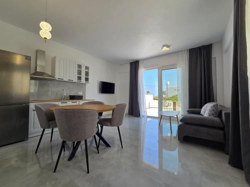 a kitchen and living room with a table and chairs at Punta Mare Hotel in Karpathos Town