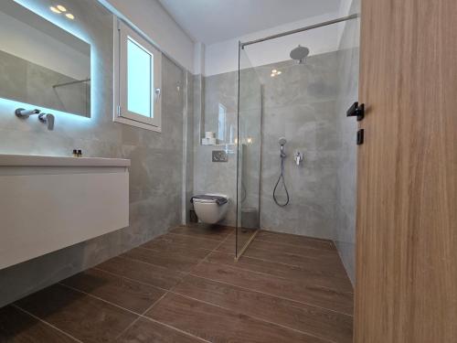a bathroom with a shower and a toilet and a sink at Punta Mare Hotel in Karpathos Town