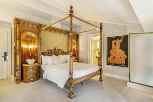 a bedroom with a canopy bed with white sheets at Hotel Bardot Boutique in Panama City