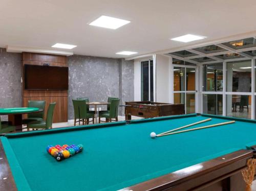 ein Billardzimmer mit Billardtisch und Stühlen in der Unterkunft ApartHotel Centro de Nova Iguaçu in Nova Iguaçu