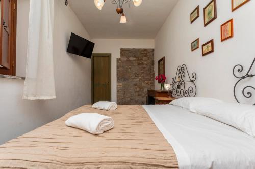 a bedroom with a large bed with two white pillows at Agriturismo Terrenia in Taormina
