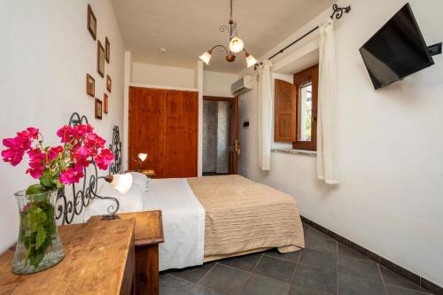 a bedroom with a bed and a vase of flowers at Agriturismo Terrenia in Taormina