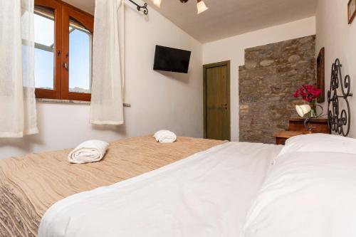 a bedroom with a large white bed with towels on it at Agriturismo Terrenia in Taormina