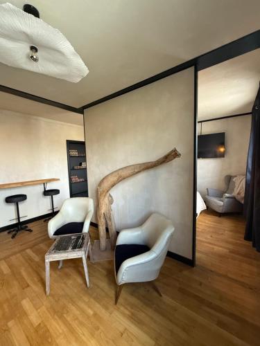 a living room with two chairs and a large wall at La Suite élégante in Saint Lo
