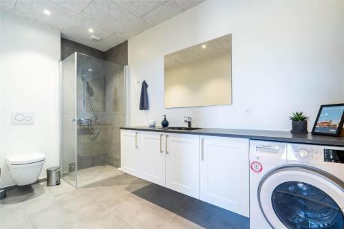 y baño con lavadora y ducha. en 907-Hvide-Sande-Langsand-108, en Hvide Sande