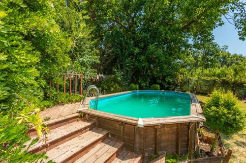 a hot tub in a garden with a wooden deck at Agriturismo Terrenia in Taormina