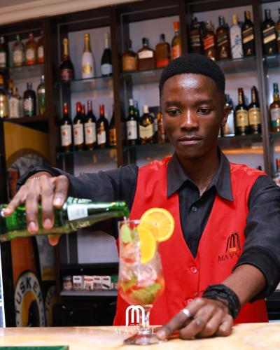 a man making a drink in a bar at The Mavvel Hotel in Kangaru
