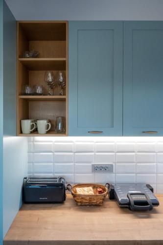 a kitchen with blue cabinets and a basket on a counter at Villa Akalli in Frangokastello