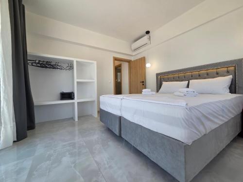 a bedroom with a large bed with white sheets at Punta Mare Hotel in Karpathos Town