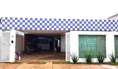 a house with a blue and white checkered roof at Casa Modernista - Aluguel de Suítes in Brasilia