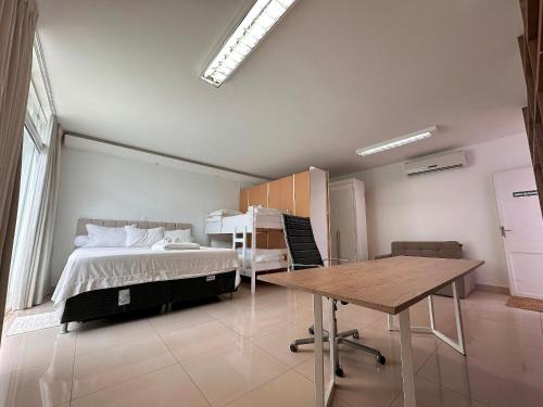 a bedroom with a bed and a table in it at Casa Modernista - Aluguel de Suítes in Brasilia