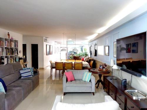 a living room with a couch and a dining room at Casa Modernista - Aluguel de Suítes in Brasilia