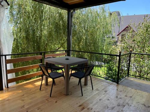 a table and two chairs on a balcony with trees at ორსაძინებლიანი კოტეჯი 