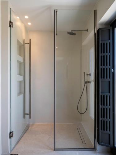 a glass shower door in a bathroom at Acrodise Estate in Santorini
