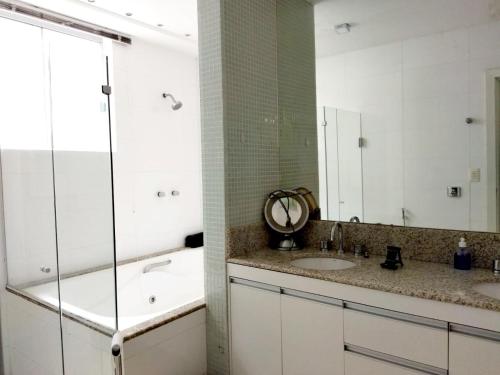 a bathroom with two sinks and a large mirror at Casa Modernista - Aluguel de Suítes in Brasilia