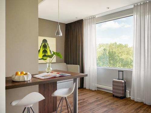 a kitchen with a table and chairs and a window at Numa Hamburg Fore in Hamburg