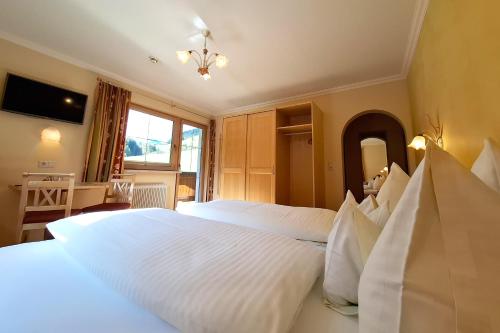 a bedroom with two white beds and a television at Haus Tirol in Tux