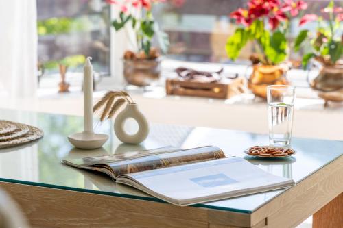 a glass table topped with a book and a candle at Roberto Hotel in Sinaia