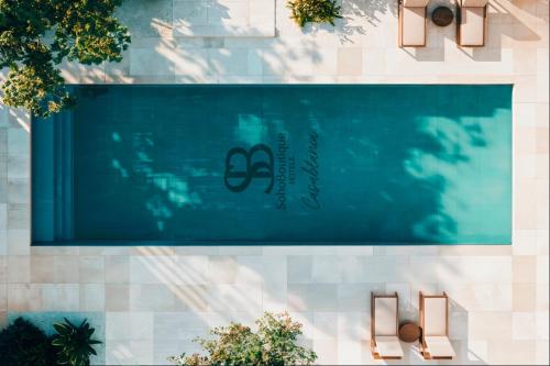 une piscine avec un panneau sur le côté d'un bâtiment dans l'établissement Soho Boutique Casablanca, à Casablanca