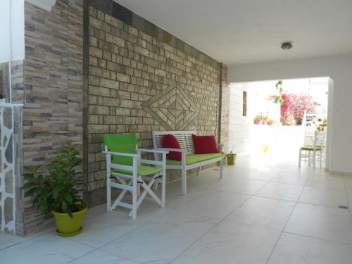 a patio with green and red chairs and a brick wall at Nicolas Antiparos in Antiparos Town