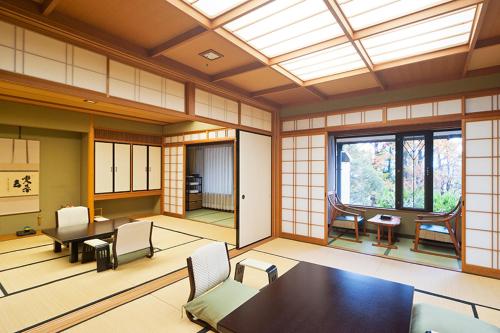 a room with a table and chairs and a window at Ryotei Manyou in Nomi