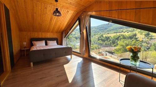 a bedroom with a bed and a large window at Varadeo Hill Resort in Şuncuiuş