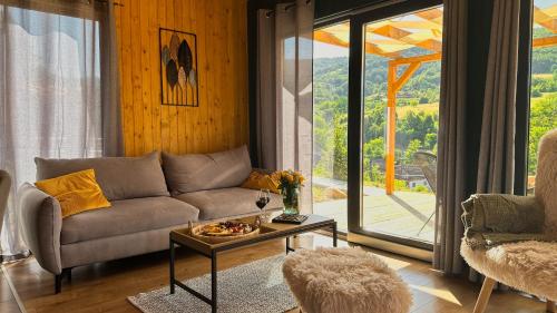 a living room with a couch and a table at Varadeo Hill Resort in Şuncuiuş