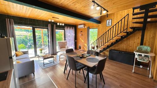 a living room with a table and chairs and a staircase at Varadeo Hill Resort in Şuncuiuş