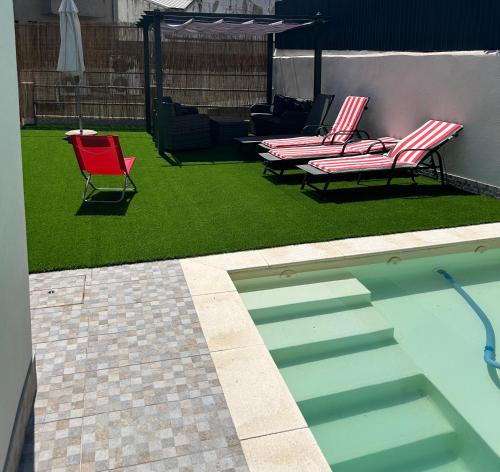 a yard with two chairs and a swimming pool at Vivenda Branca Martinho I in Peso da Régua