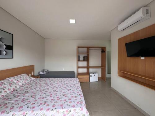 a bedroom with a bed and a flat screen tv at Casa Piscina Centro BonitoMS in Bonito