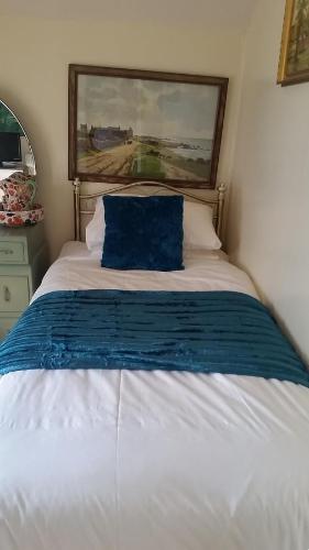 a bed with a blue pillow on top of it at West View B&B dog friendly Atwick in Atwick